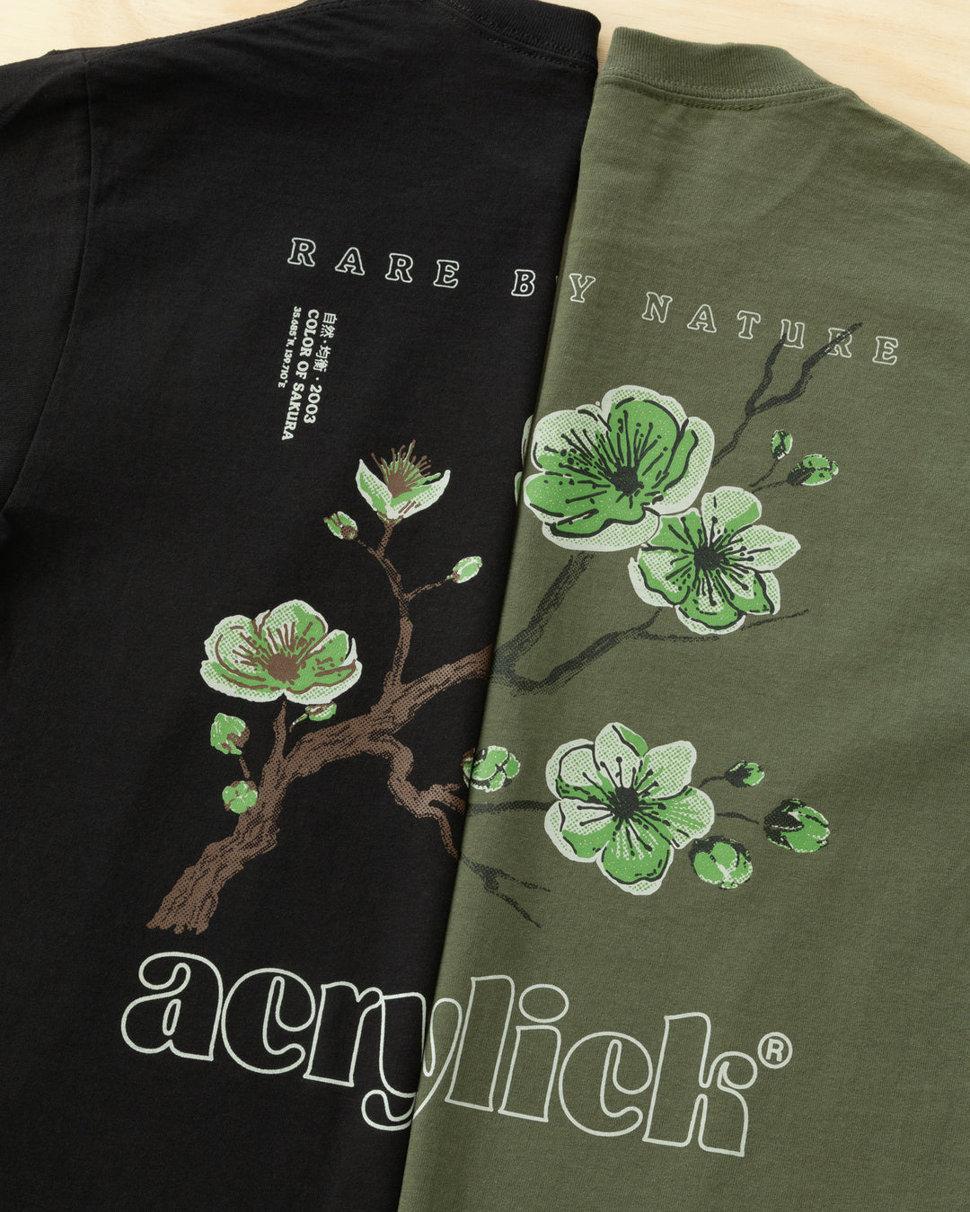Green sakura branch in bloom, symbolizing rarity, growth, and natural balance. Acrylick Zen Capsule Tee.