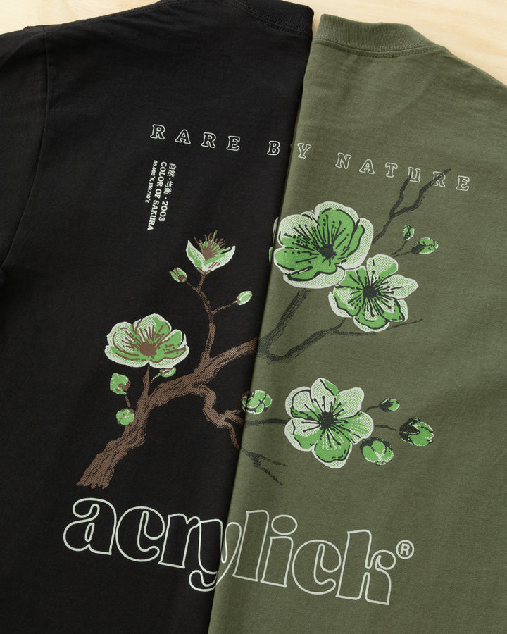 Green sakura branch in bloom, symbolizing rarity, growth, and natural balance. Acrylick Zen Capsule Tee.