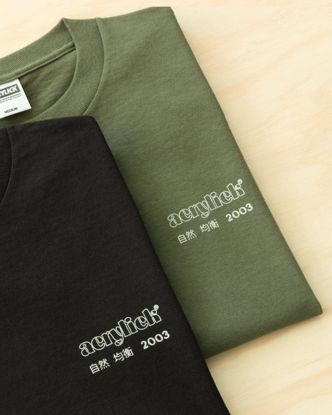 Green sakura branch in bloom, symbolizing rarity, growth, and natural balance. Acrylick Zen Capsule Tee.