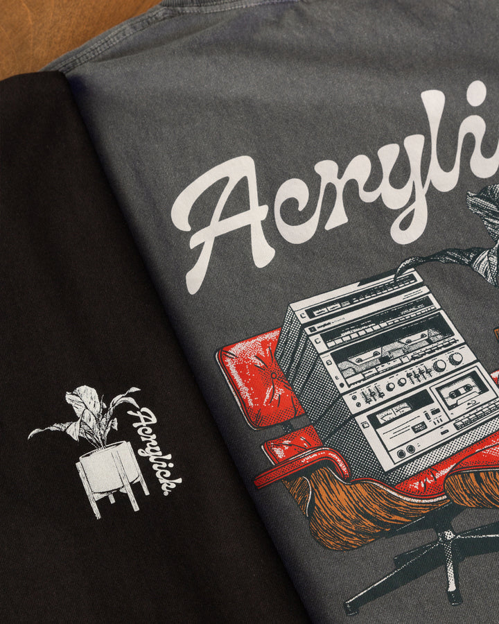 Mid-century style lounge chair holding a vintage hi-fi stereo, paired with a peace lily in a modern planter, representing relaxed listening and thoughtful living.