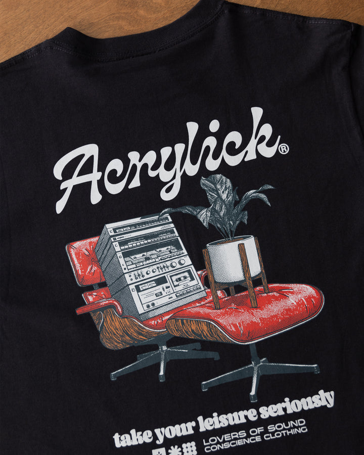 Mid-century style lounge chair holding a vintage hi-fi stereo, paired with a peace lily in a modern planter, representing relaxed listening and thoughtful living.