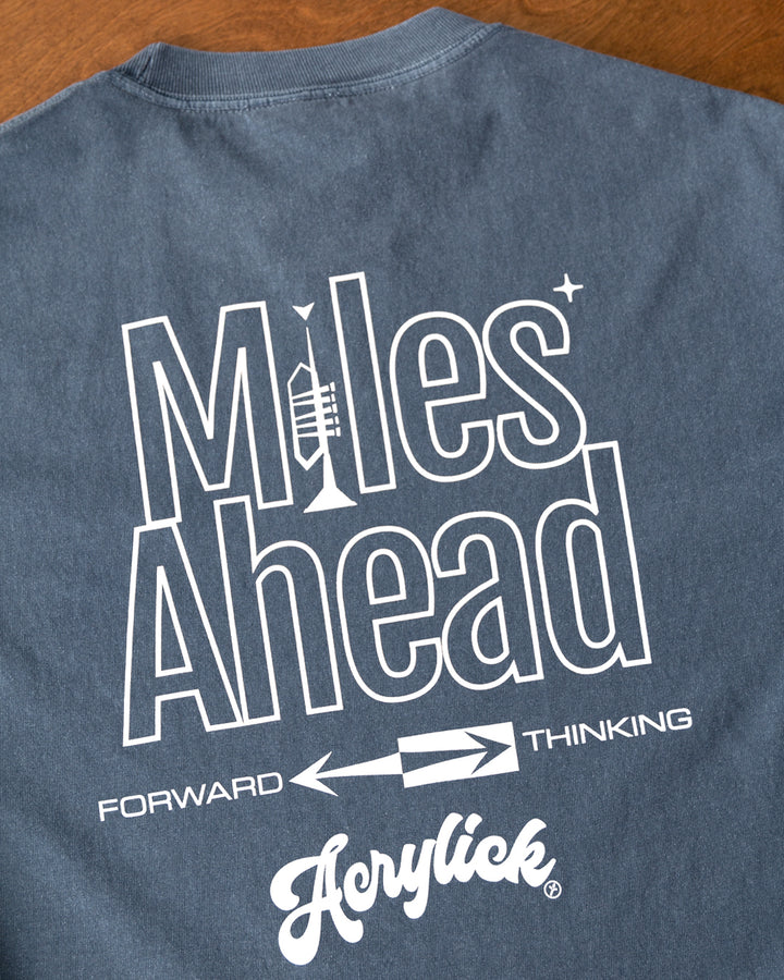 Minimal graphic featuring a trumpet forming the letter “I” in “Miles,” with mid-century arrows pointing forward to represent progress and forward thinking.