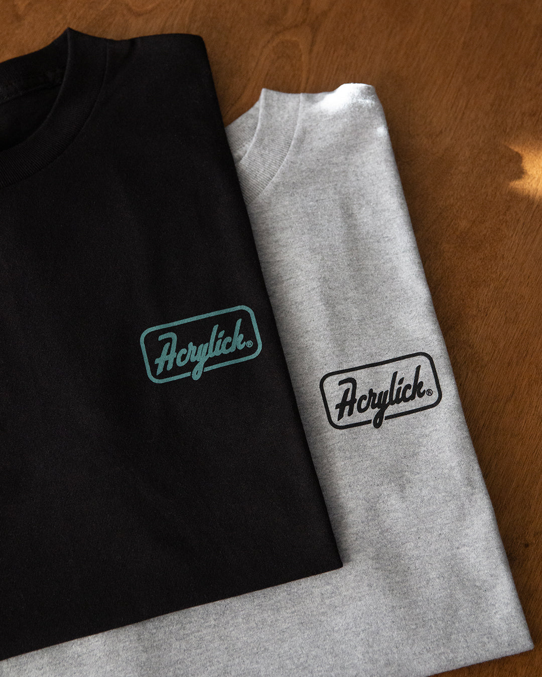 Retro script-style badge logo reading “Acrylick” and “Quality Goods,” inspired by classic signage and heritage branding.